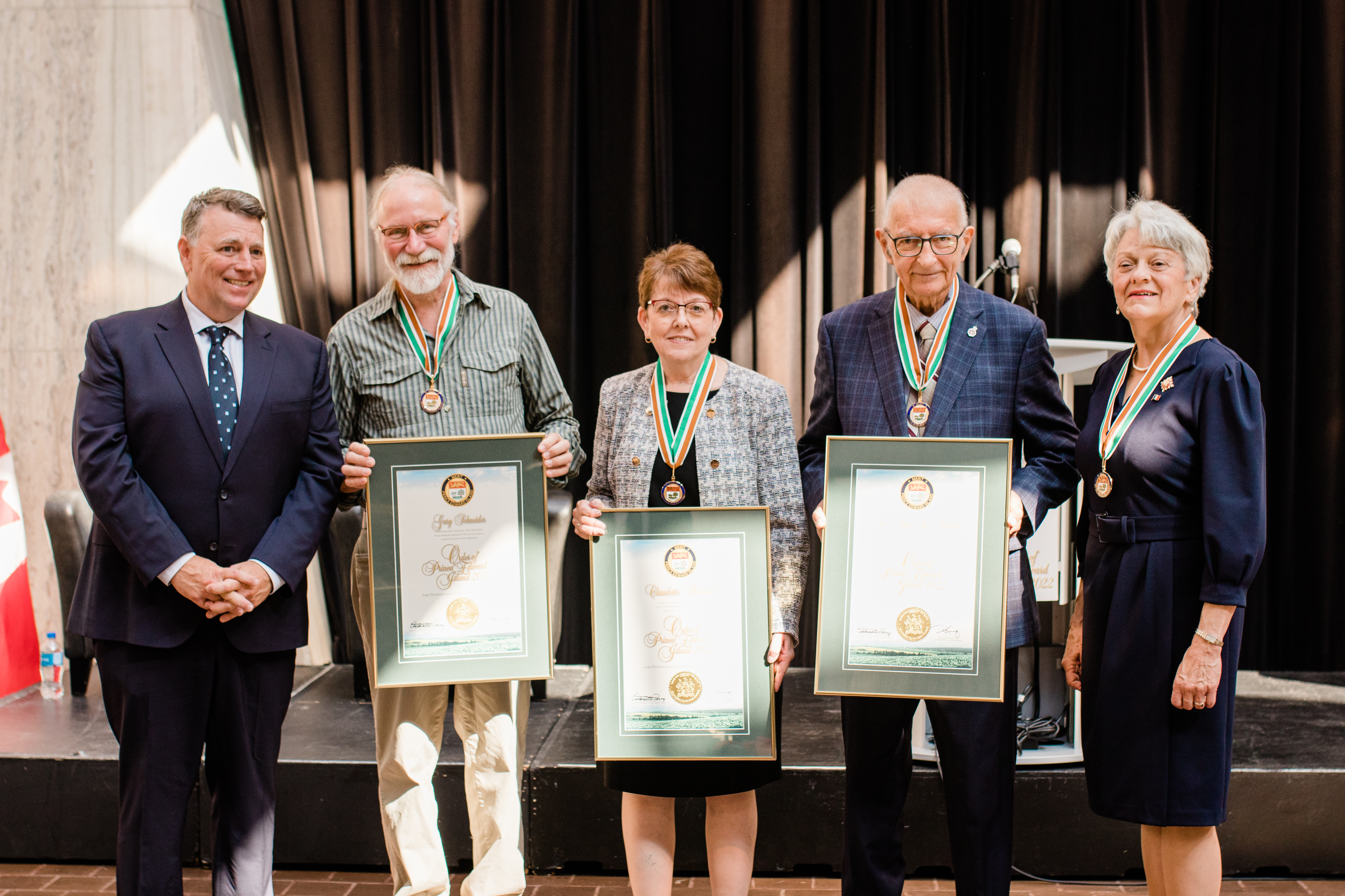 A photo of Premier Dennis King and Lieutenant Governor Antoinette Perry with the 2022 Medal of Merit recipients, Gary Schneider, Claudette Thériault, and Dr. John Andrew