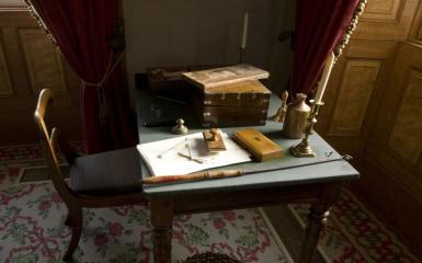 An image of an antique desk with papers on it