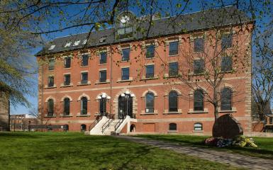 An image of the Hon. George Coles Building, a red brick building